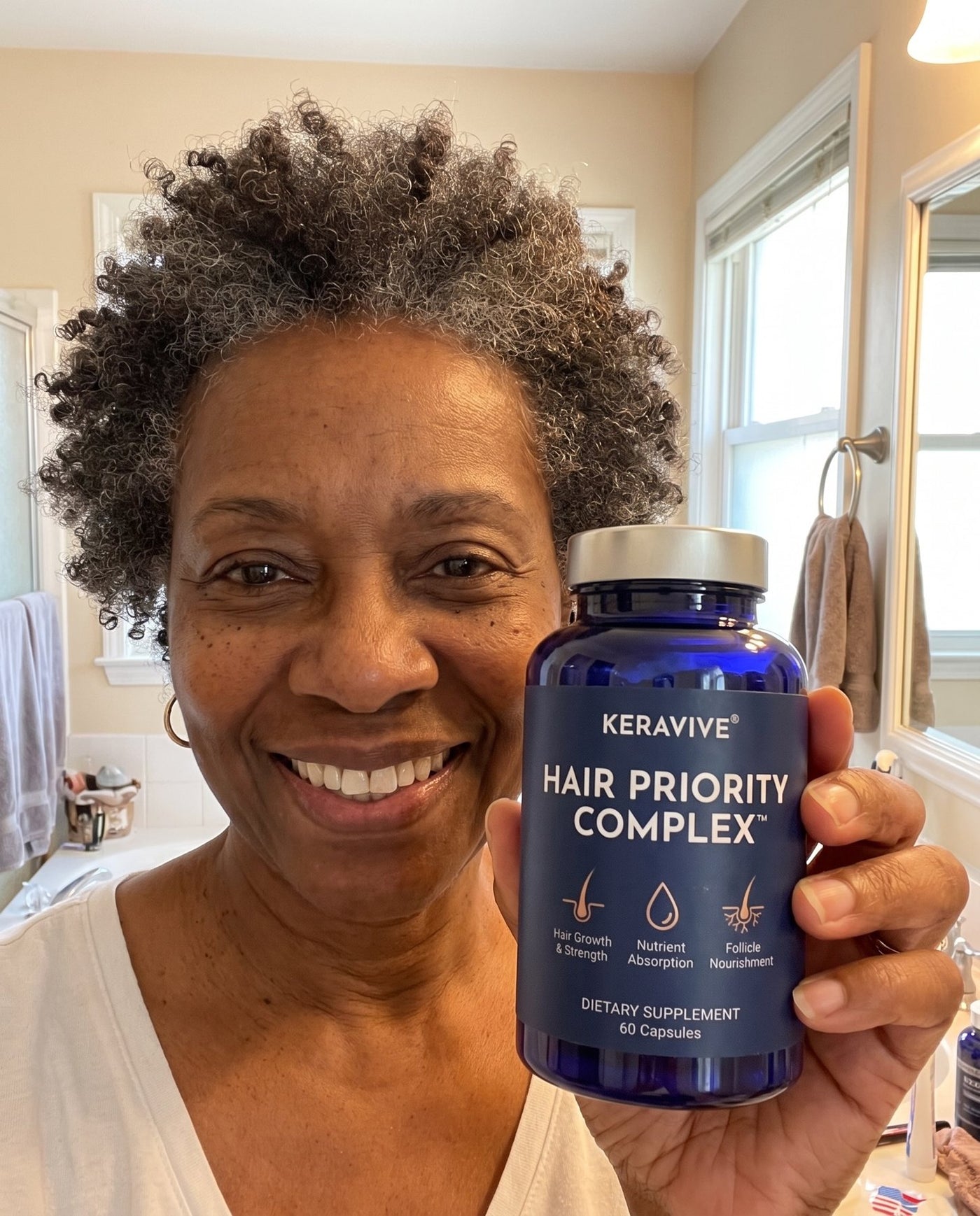 A customer holding the Hair Priority Complex bottle